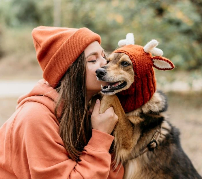 Bicho canino sendo beijado por sua dona